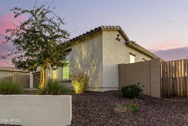 property exterior at dusk featuring a garage