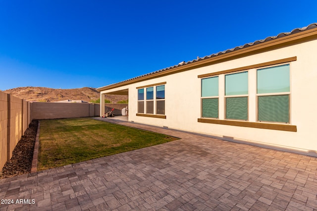 exterior space featuring a patio, a yard, and a mountain view