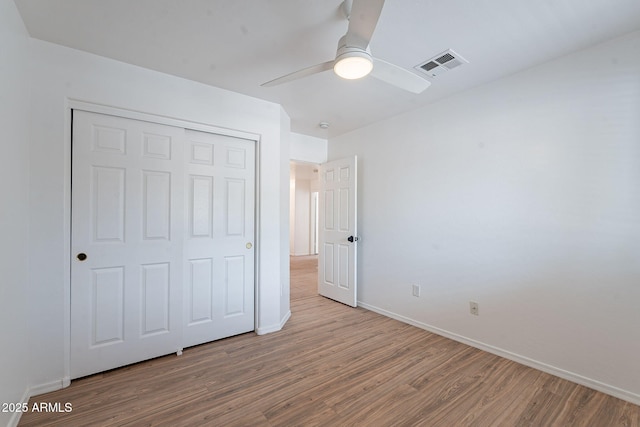 2518 W Carson Rd, Phoenix, AZ 85041 - unfurnished bedroom with wood finished floors, baseboards, a closet, and a ceiling fan