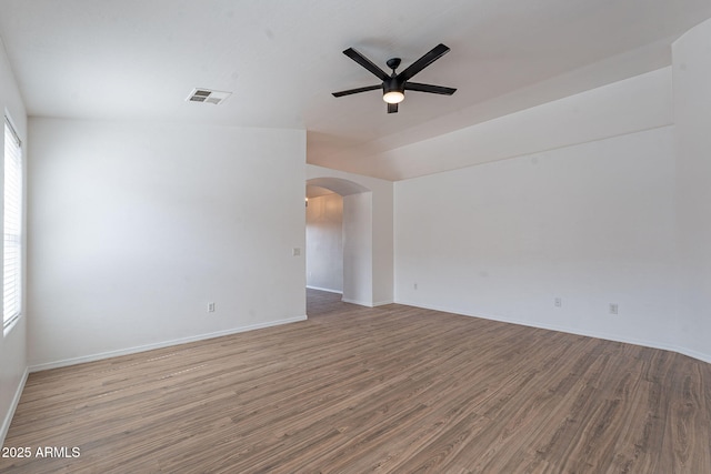 2518 W Carson Rd, Phoenix, AZ 85041 - spare room featuring a ceiling fan, arched walkways, wood finished floors, and baseboards