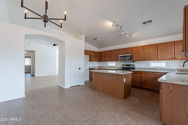 2518 W Carson Rd, Phoenix, AZ 85041 - kitchen with stainless steel appliances, lofted ceiling, a sink, a kitchen island, and brown cabinets