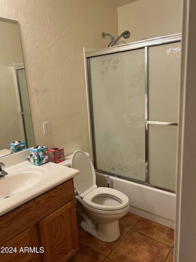 full bathroom featuring tile patterned floors, vanity, toilet, and enclosed tub / shower combo