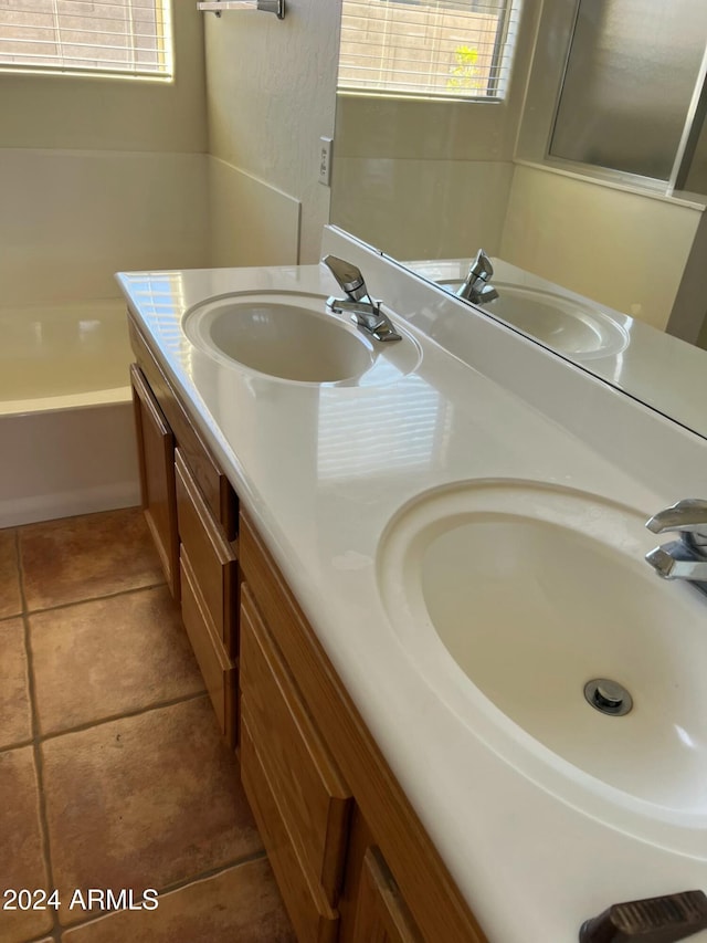 bathroom featuring tile patterned floors, vanity, and a bath