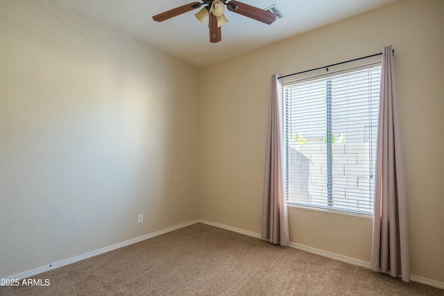 carpeted spare room featuring plenty of natural light and ceiling fan