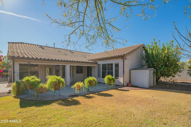 back of property featuring a patio, a storage shed, and a lawn