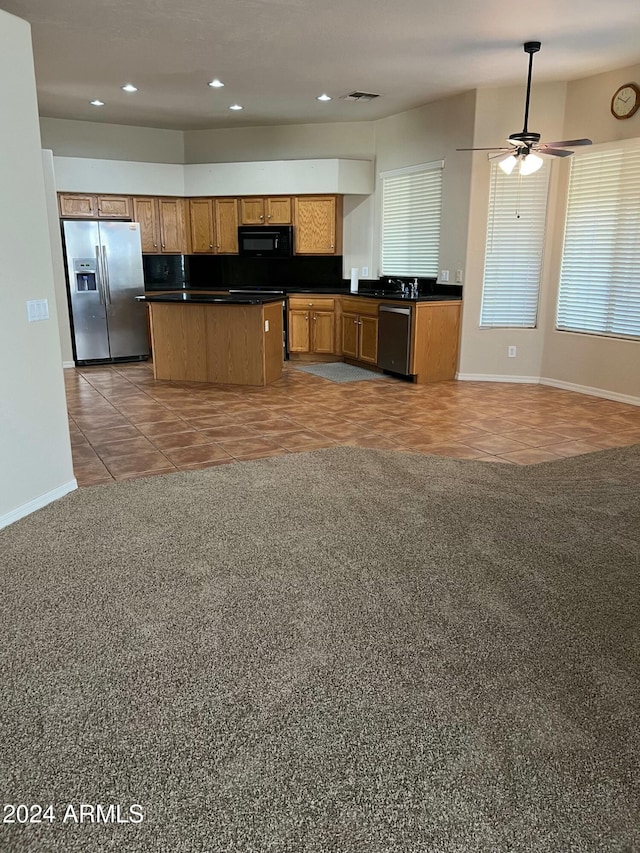 kitchen with a center island, ceiling fan, light tile patterned flooring, and appliances with stainless steel finishes