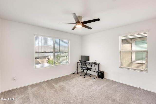 carpeted home office featuring ceiling fan