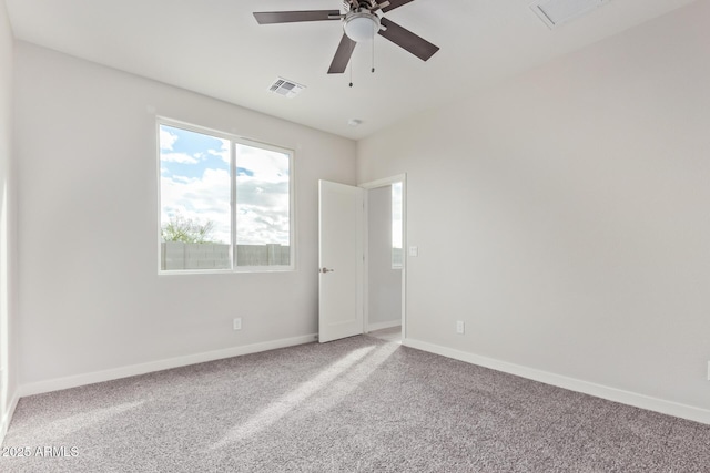 empty room with visible vents, baseboards, carpet, and a ceiling fan