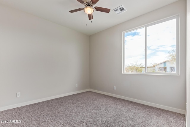 empty room featuring a ceiling fan, plenty of natural light, carpet, and baseboards