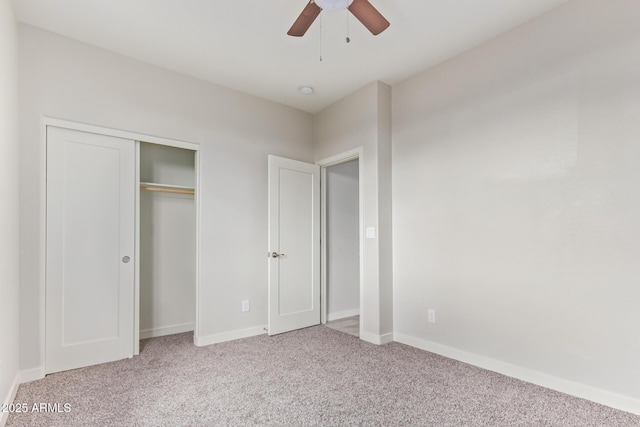 unfurnished bedroom featuring a ceiling fan, light colored carpet, baseboards, and a closet