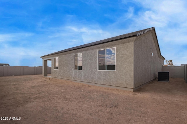 back of property featuring cooling unit, a fenced backyard, and stucco siding