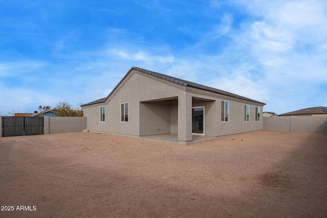 back of property with stucco siding, a patio, and a fenced backyard