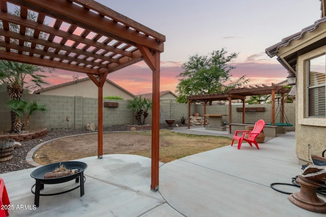 patio terrace at dusk with a pergola and an outdoor fire pit