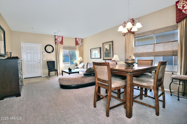 carpeted dining area featuring an inviting chandelier