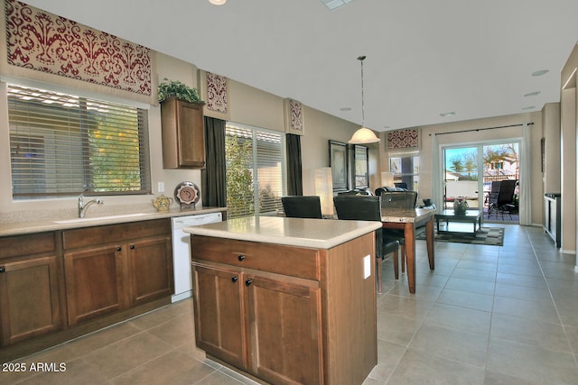 kitchen featuring sink, a center island, light tile patterned floors, dishwasher, and pendant lighting