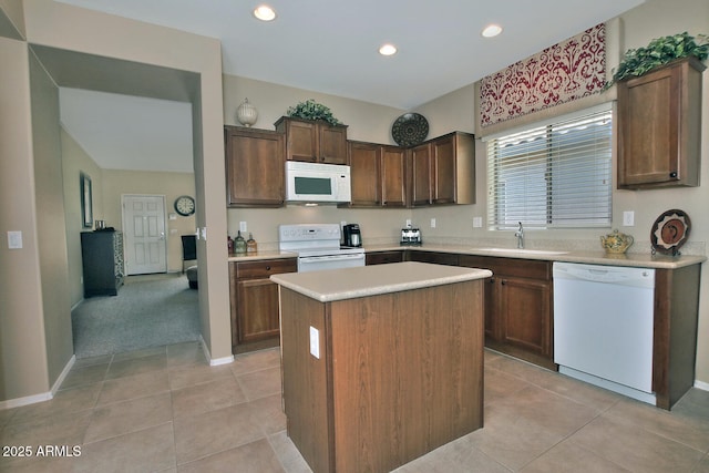 kitchen with white appliances, sink, a kitchen island, and light tile patterned floors