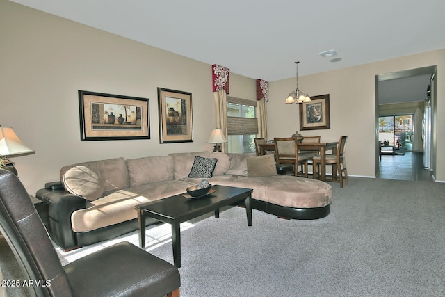 living room with a chandelier, a healthy amount of sunlight, and carpet flooring