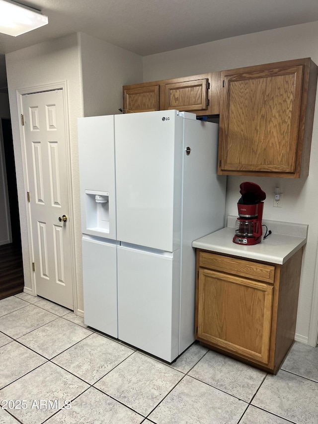100 N Lariat Way, Payson, AZ 85541 - kitchen featuring white fridge with ice dispenser, light tile patterned floors, light countertops, and brown cabinets