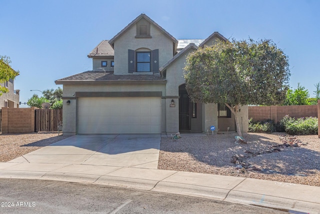view of front of property featuring a tiled roof, fence, driveway, and stucco siding