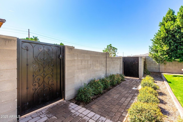 view of gate with a fenced backyard