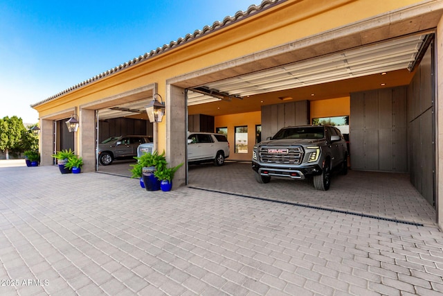 view of parking / parking lot featuring a garage and decorative driveway