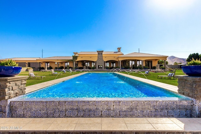 outdoor pool featuring a yard