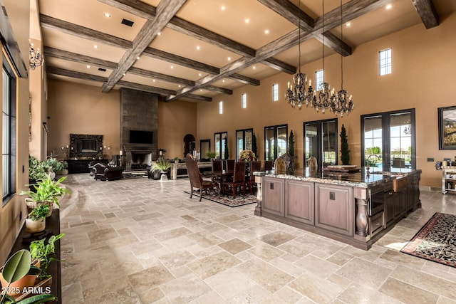 kitchen with decorative light fixtures, open floor plan, dark brown cabinets, light stone countertops, and coffered ceiling