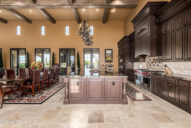 kitchen with a center island, french doors, double oven range, and light stone countertops