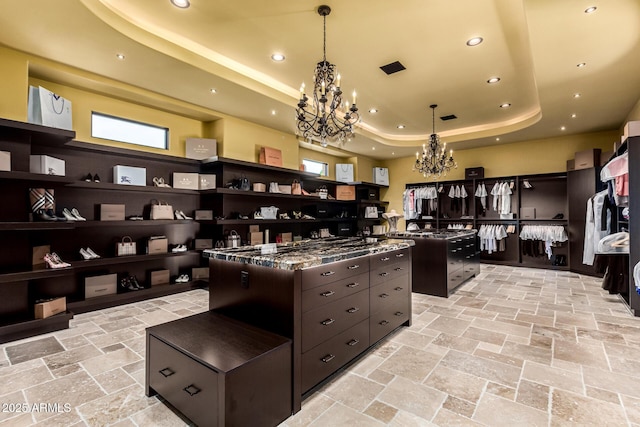 kitchen with dark brown cabinetry, stone tile floors, a kitchen island, a tray ceiling, and open shelves