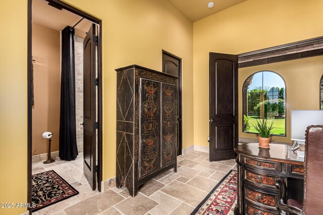 interior space featuring baseboards and stone tile flooring