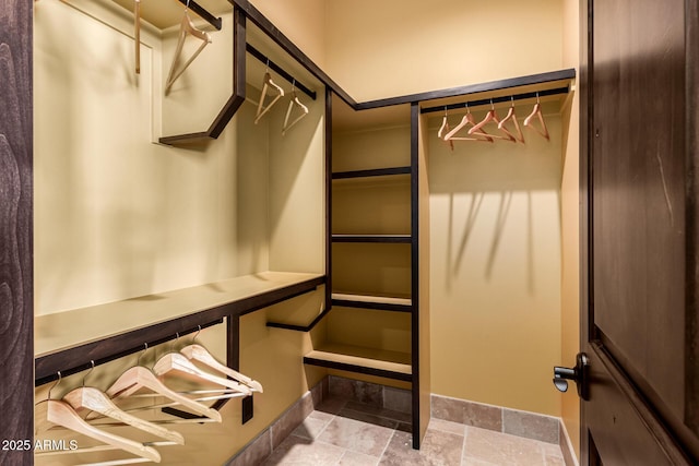 spacious closet with stone tile floors