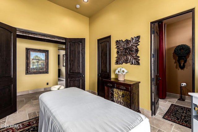 bedroom with baseboards, stone tile flooring, and recessed lighting