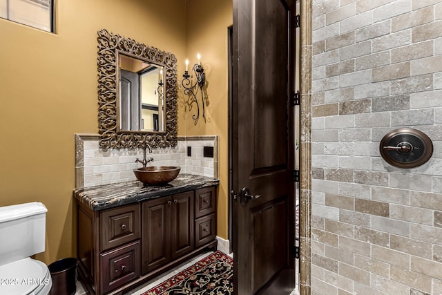 bathroom with toilet, backsplash, and vanity