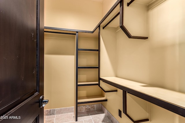 spacious closet with stone finish floor