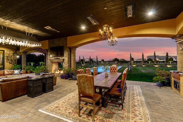 view of patio with an outdoor living space with a fireplace, a pool, and outdoor dining space