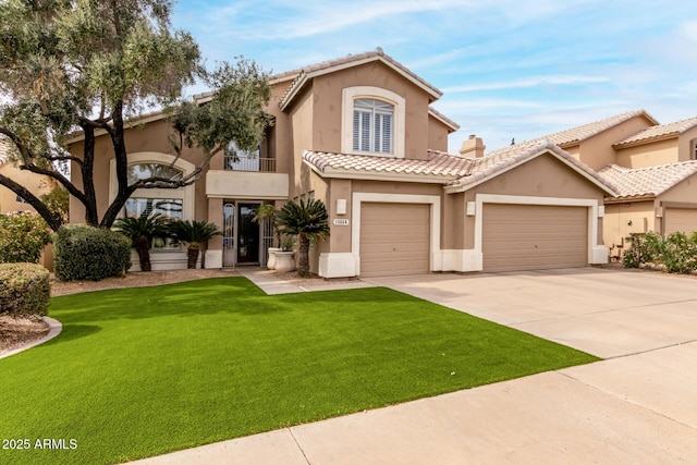 mediterranean / spanish-style home featuring a tile roof, a front lawn, concrete driveway, and stucco siding