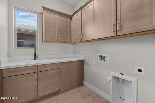 washroom featuring hookup for a washing machine, cabinet space, a sink, electric dryer hookup, and baseboards