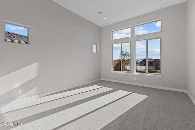 carpeted empty room with visible vents and baseboards