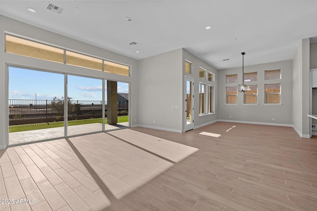 unfurnished living room featuring light wood-style floors, recessed lighting, visible vents, and baseboards