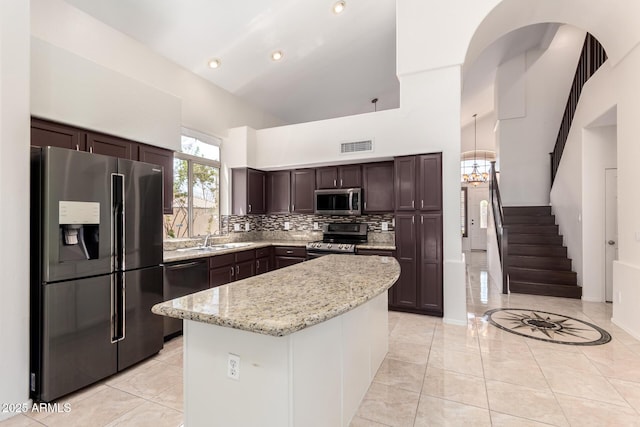 2741 E San Tan St, Chandler, AZ 85225 - kitchen featuring appliances with stainless steel finishes, high vaulted ceiling, dark brown cabinetry, tasteful backsplash, and a kitchen island