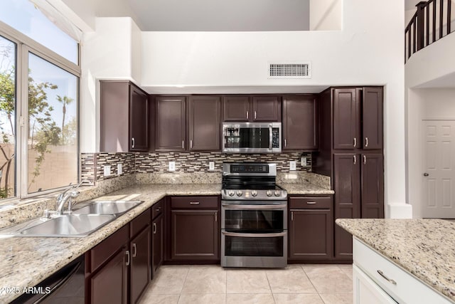 2741 E San Tan St, Chandler, AZ 85225 - kitchen featuring stainless steel appliances, tasteful backsplash, light tile patterned flooring, dark brown cabinetry, and a high ceiling