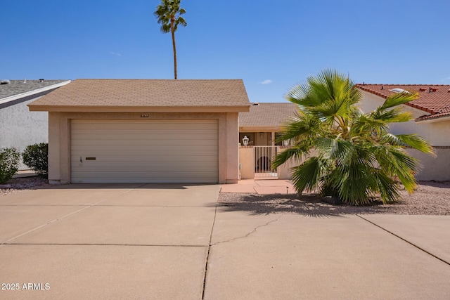 view of front facade featuring stucco siding, an attached garage, driveway, and a gate