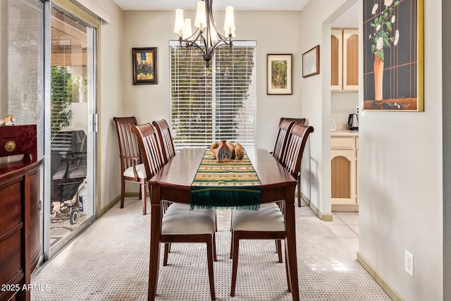 dining space featuring baseboards and a chandelier