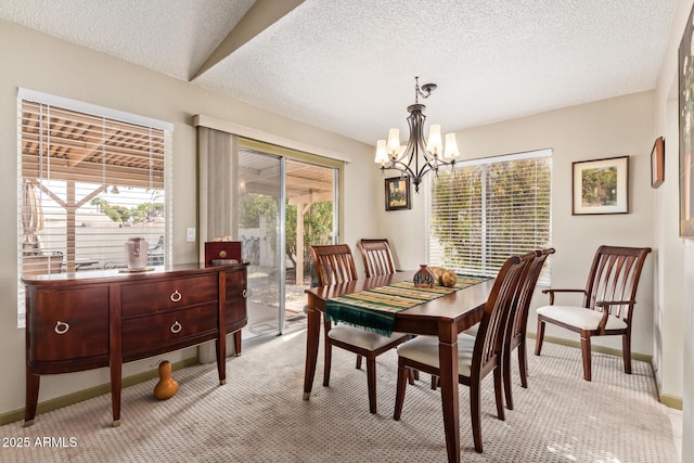 dining space featuring a notable chandelier, light colored carpet, baseboards, and a textured ceiling