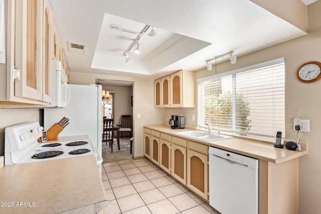 kitchen featuring visible vents, white appliances, a textured ceiling, a raised ceiling, and a sink