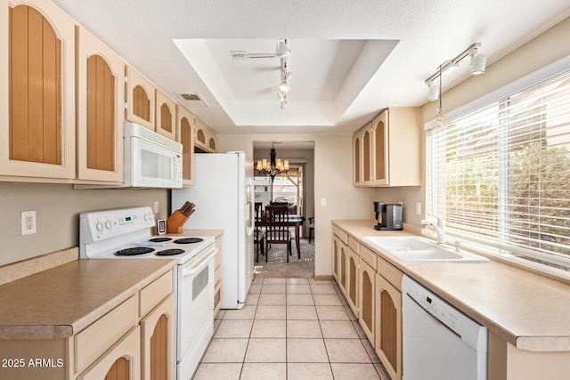 kitchen with a chandelier, light tile patterned floors, white appliances, a raised ceiling, and a sink