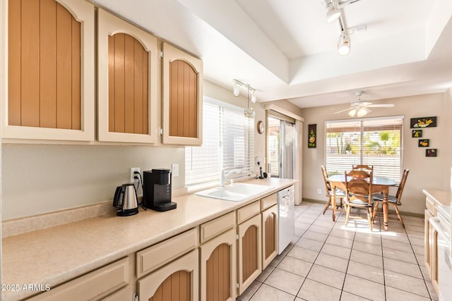 kitchen with a ceiling fan, light tile patterned flooring, white dishwasher, a sink, and light countertops