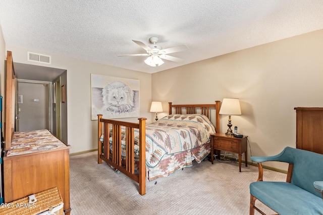 bedroom featuring baseboards, visible vents, ceiling fan, a textured ceiling, and light colored carpet