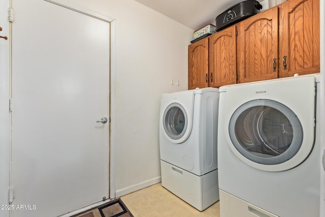 clothes washing area with washer and clothes dryer and cabinet space