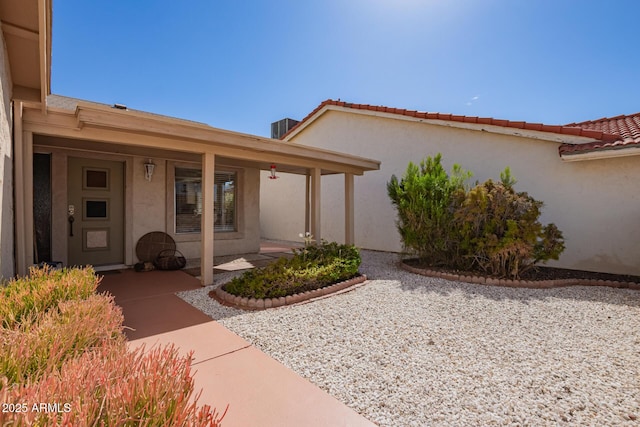 doorway to property with a tile roof and stucco siding